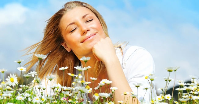 mUJER FELIZ EN PRIMAVERA RODEADA DE MARGARITAS