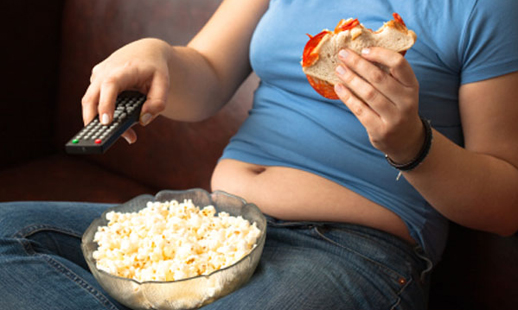 Persona en el sofá comiendo mal