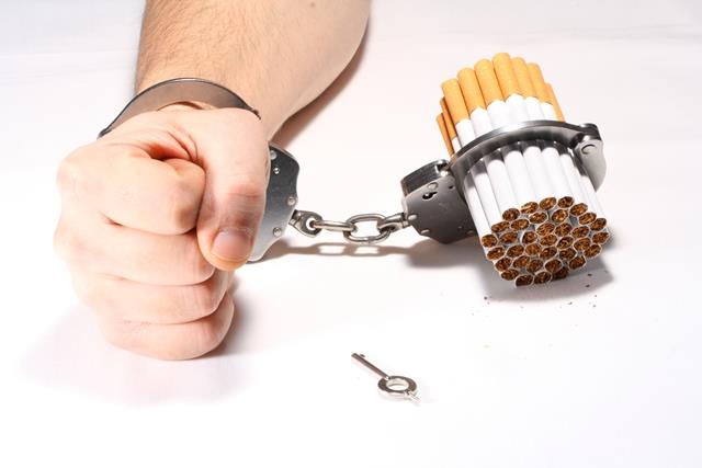 Hombre esposado a un puñado de cigarrillos