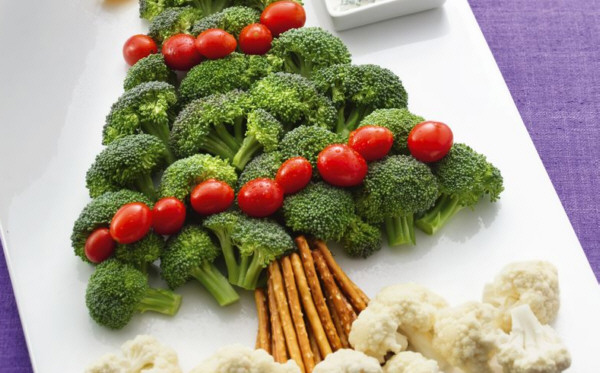 Plato blanco con brocoli, tomates y coliflor simulando un arbol de navidad con sus bolas y la nieve a los pies