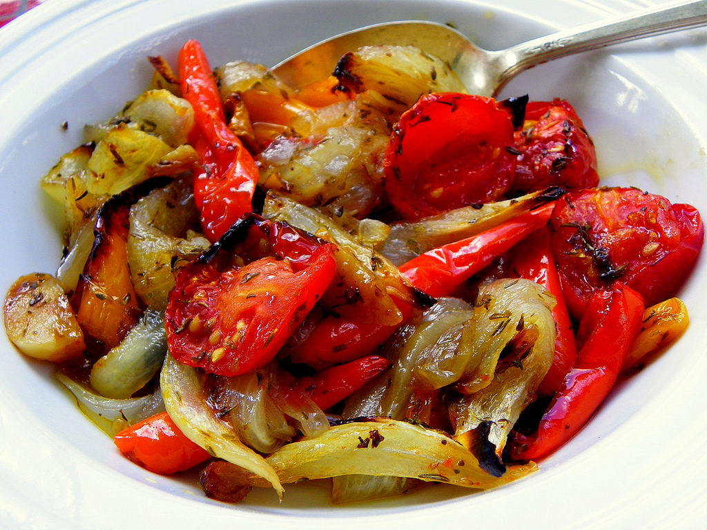 Plato blanco con escalibada de verduras y una cuchara metálica