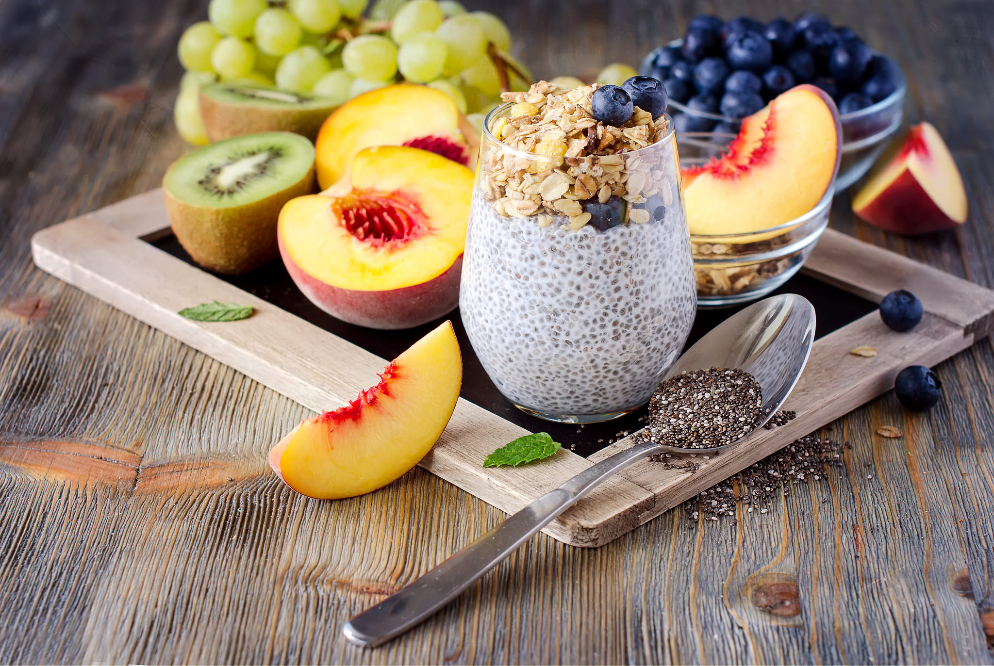 Mesa de madera con fruta,semillas de chia, cuchara metálica...
