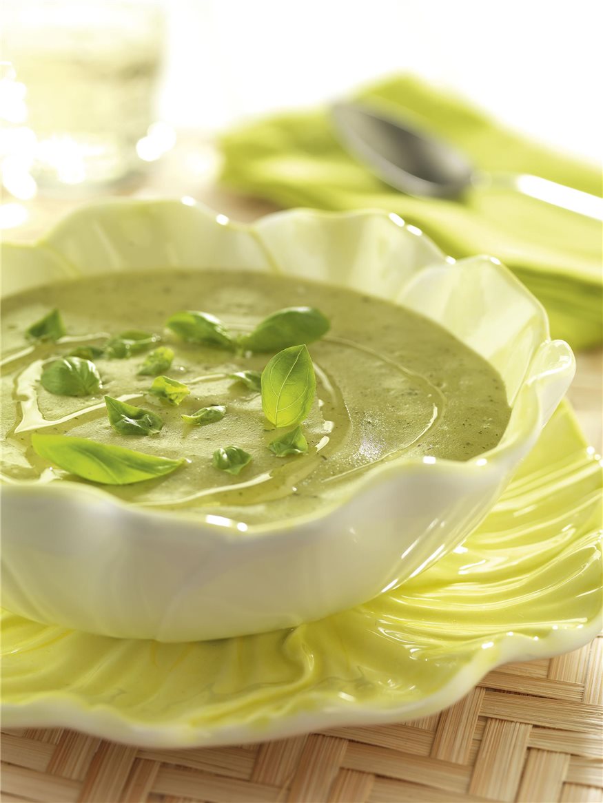 Plato blanco sobre plato verde con crema de albahaca,cebollino y perejil