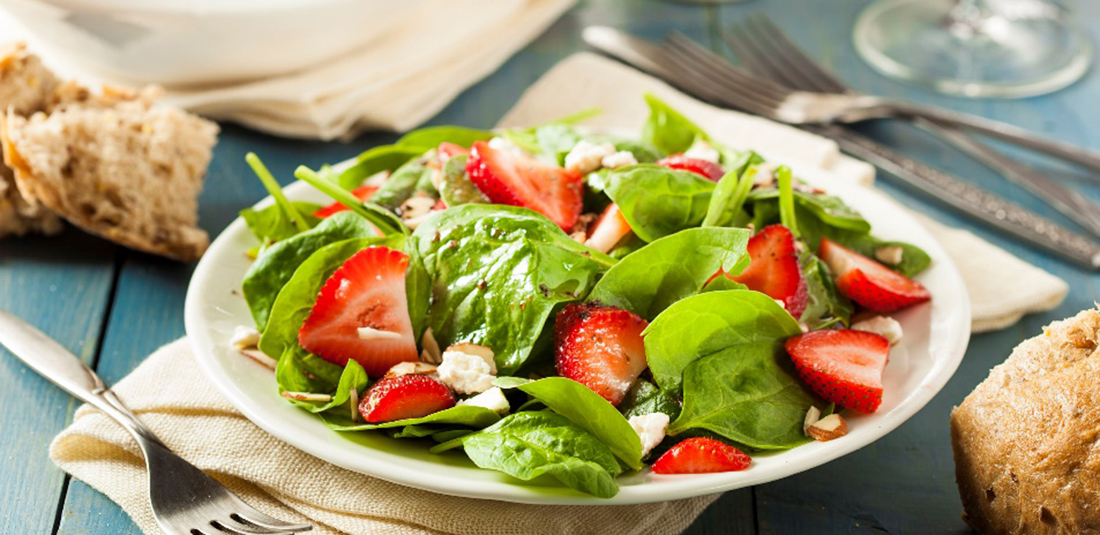 Plato blanco con ensalada de espinacas y fresas