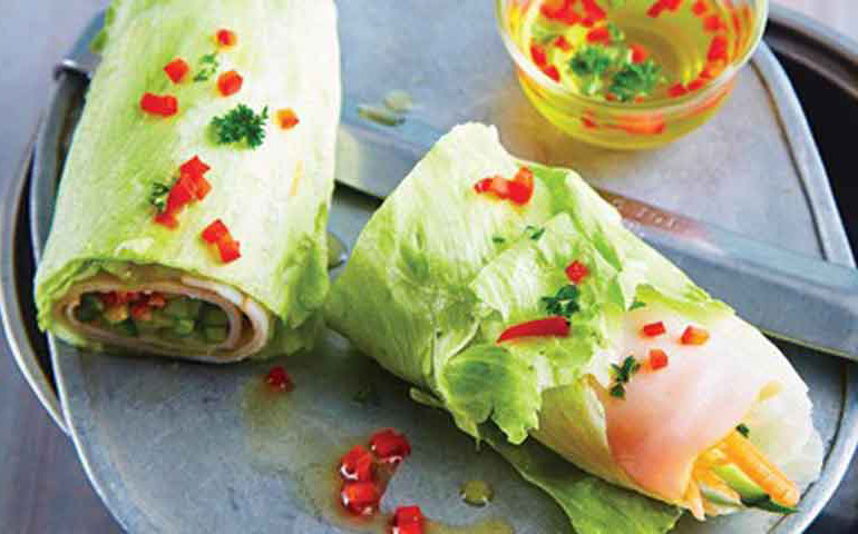 wrap de lechuga con pechuga de pavo y vinagreta de verduras sobre tabla de pizarra