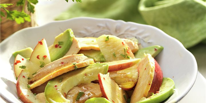 Plato blanco con ensalada de pollo, manzana y aguacate