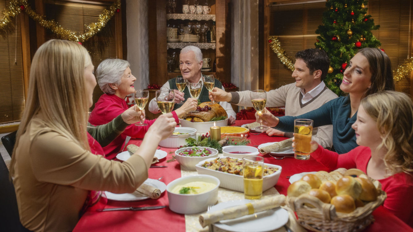 Familia alrededor de una mesa celebrando la navidad