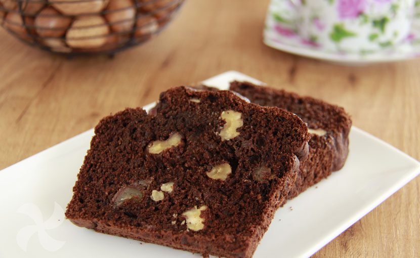 Bizcocho de chocolate y nueves sobre plato blanco en mesa de madera