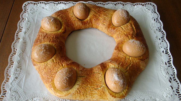 Mona de pascua con huevos duros sobre mantel de papel blanco