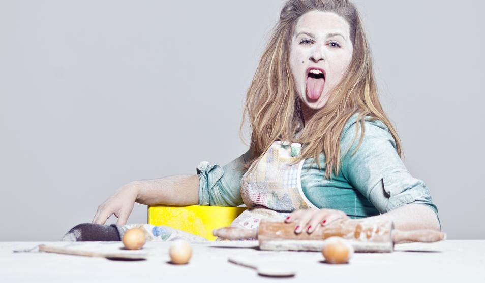 Mujer llena de harina con ingredientes sobre mesa blanca
