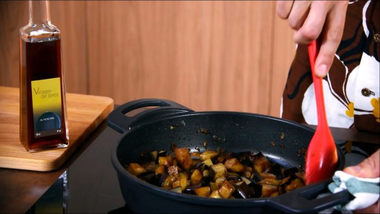 Mujer cocinando berenjenas al ajillo