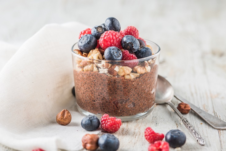 Vaso de cristal con pudin de chia con chocolate, frutos secos y frutos rojos