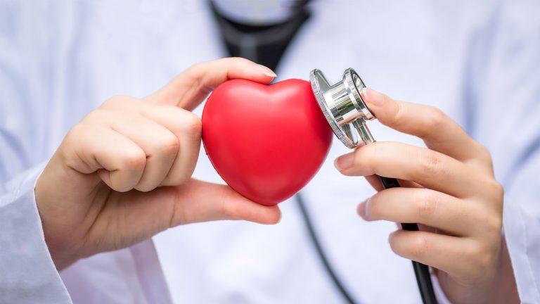 Persona con bata blnaca controlando tensión a un corazón
