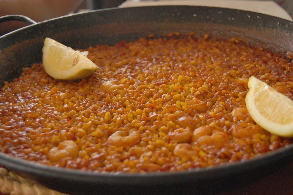 Paellera de arroz a banda con gambas y sepia
