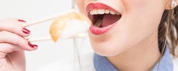Mujer comiendo pescado crudo