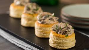 Volovanes rellenos de boletus sobre tabla de pizarra