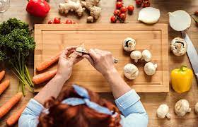 Mujer delnate de tabla de cortar alimentos cortando verduras
