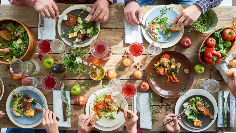 Mesa de madera y ncima platos con alimentos muy variados