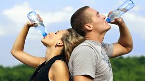 mujer y himbre bebiendo agua mineral