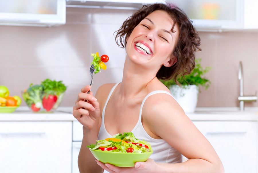 Mujer contenta de comerse una ensalada