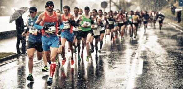 Gente corriendo bajo la lluvia en la carrera behobia - San sebastian