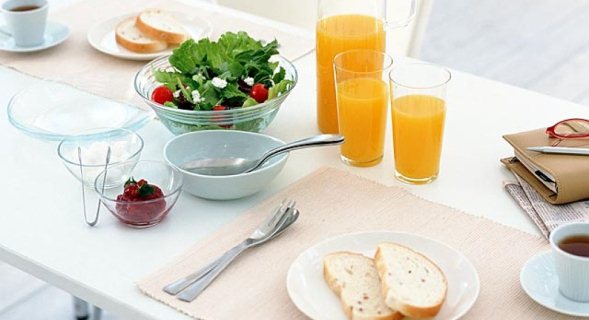 Mesa con tostadas,zumo de naranja y ensalada
