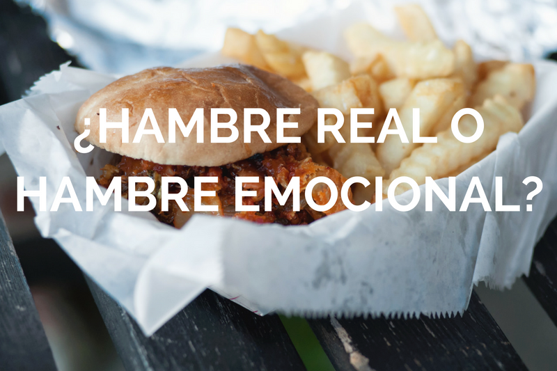 Foto de hamburguesa con pattas con letras blancas por encima donde se llee hambre real o emocional