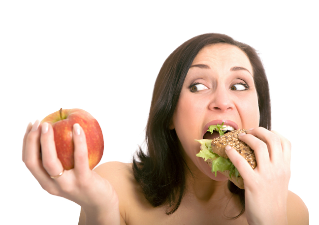 Mujer comiéndose una hamburguesa y dudando si comerse una manzana