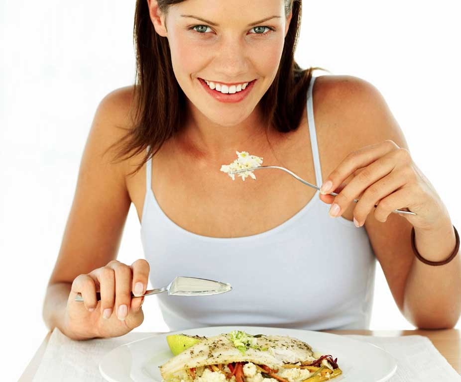 Mujer feliz comiendo pescado
